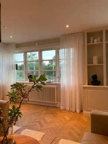 Tunna vita gardiner i ett vardagsrum i Göteborg
