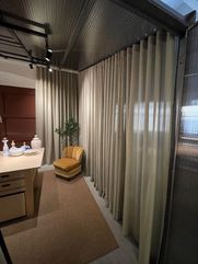 En lounge area på ett kontor med måttanpassade gardiner för insynsskydd.